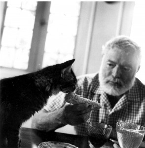 Hemingway feeding his cat